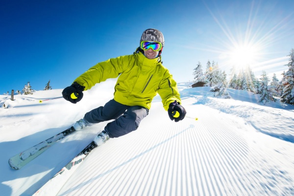 Skifahrer auf präparierter Piste bei sonnigem Skiwetter